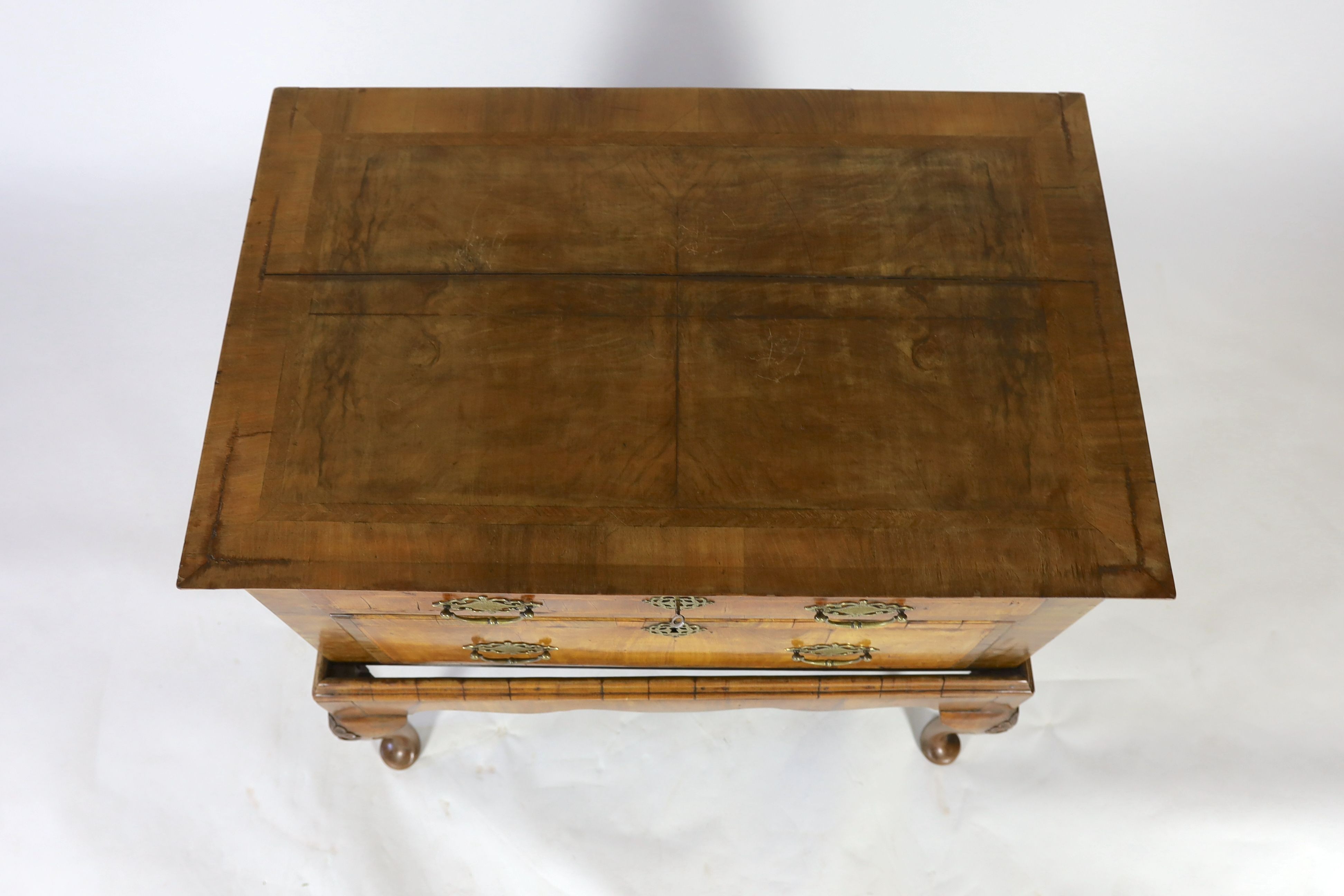 A mid 18th century featherbanded walnut chest on stand, with moulded quarter veneered top, one long and one deep drawer, on stand with shell kneed cabriole legs and pad feet, width 96cm depth 62cm height 93cm